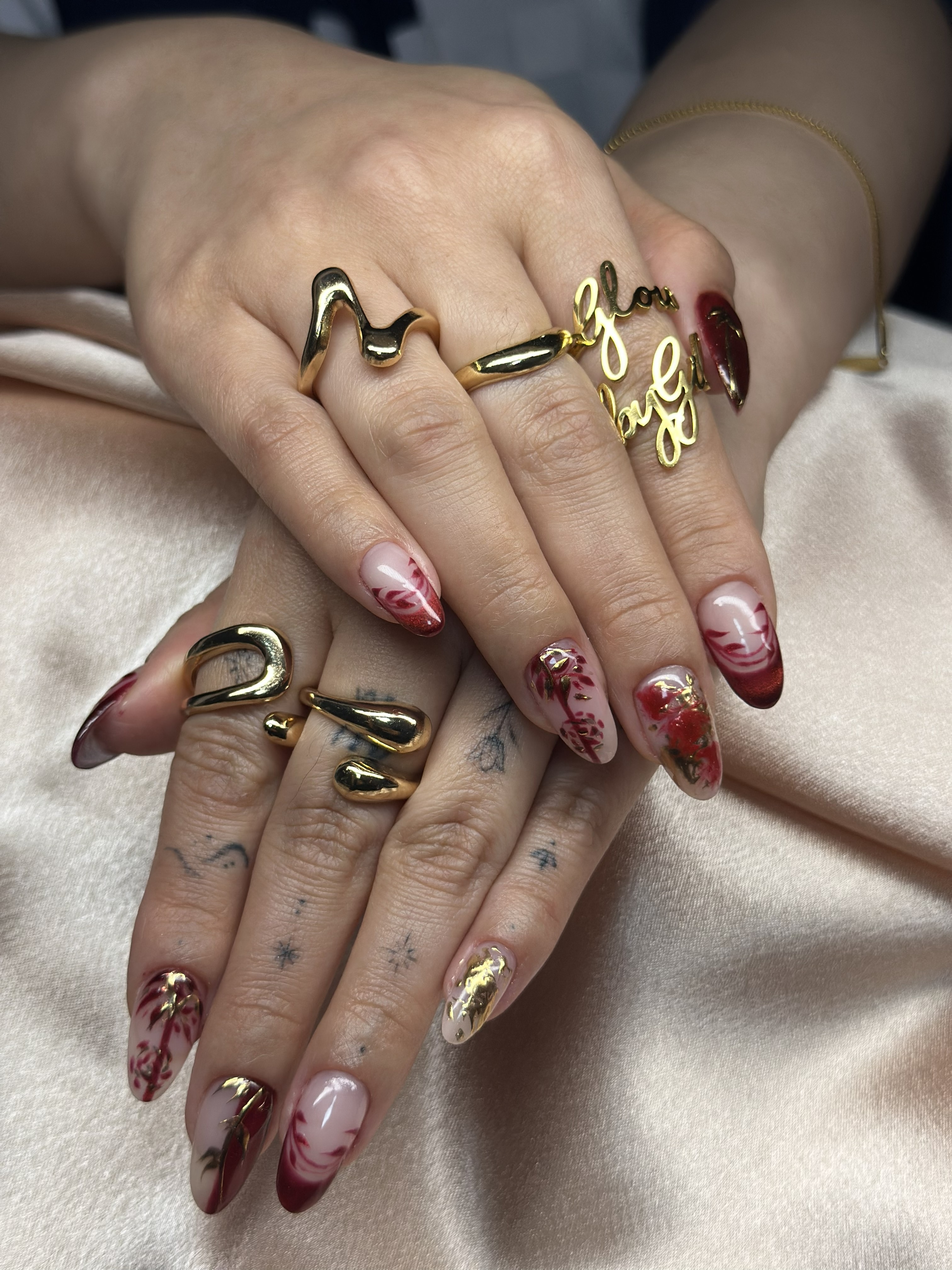 Bespoke burgundy and gold botanical nail art on pink satin